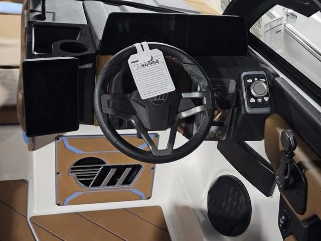 Slide: The Image of 2025 Malibu 23 LSV boat dashboard with steering wheel and control panel. - 38