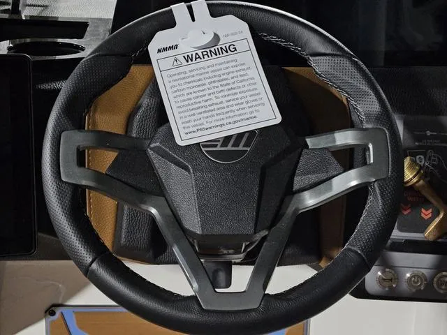 Slide: The Image of Steering wheel of 2025 Malibu 23 LSV boat with warning tag attached. - 40