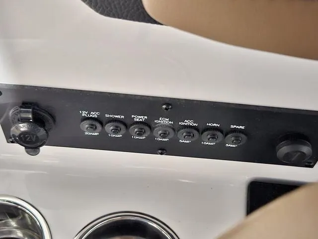 Slide: The Image of Control panel of a 2025 Malibu 23 LSV boat with labeled switches and outlets. - 49
