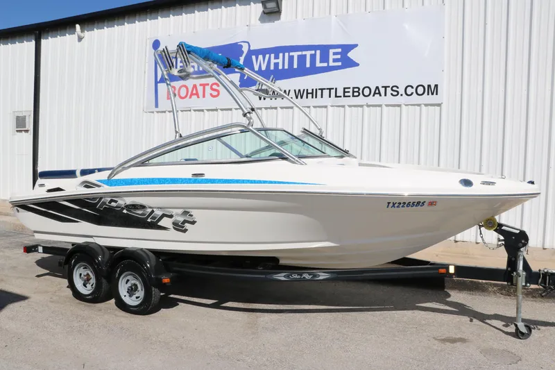 Slide: The Image of 2011 Sea Ray 205 Sport boat on trailer, displayed outside dealership. - 14