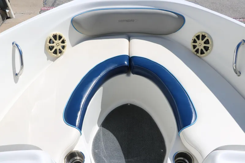 Slide: The Image of 2011 Sea Ray 205 Sport boat interior with blue and white seating, docked at marina. - 22