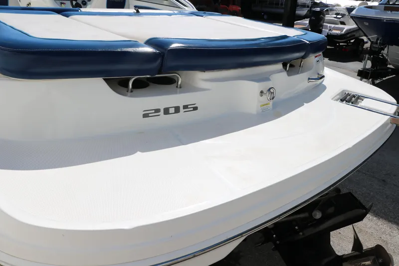 Slide: The Image of 2011 Sea Ray 205 Sport boat rear view with blue seating and white deck. - 36