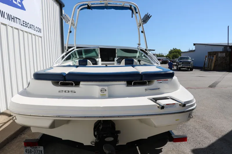 Slide: The Image of 2011 Sea Ray 205 Sport boat, rear view, parked outdoors near a building. - 5