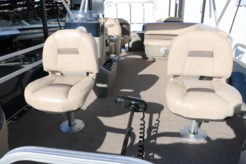Slide: The Image of 2023 Sun Tracker 18 BASS BUGGY interior with beige seating and steering console. - 15