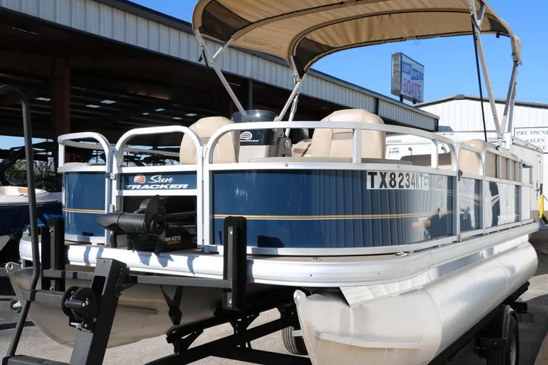 Slide: The Image of 2023 Sun Tracker 18 Bass Buggy pontoon boat with canopy, docked at marina. - 7