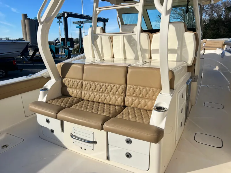 Slide: The Image of Luxurious seating on 2017 Scout 420 LXF boat with tan upholstery and storage drawers. - 10