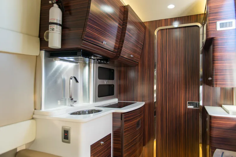 Slide: The Image of Luxurious interior of 2017 Scout 420 LXF boat with modern wood finish and kitchenette. - 16