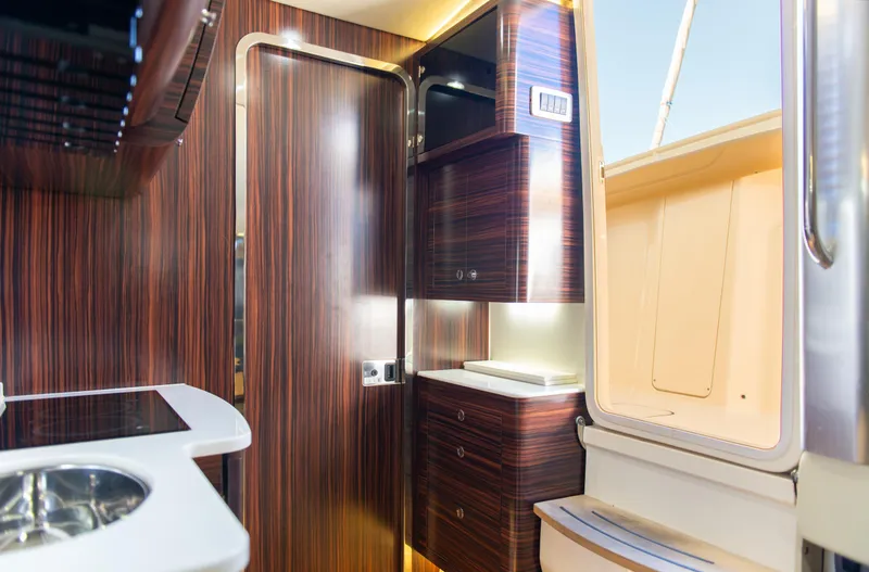 Slide: The Image of Interior of 2017 Scout 420 LXF boat with modern wood finish and sleek cabinetry. - 17