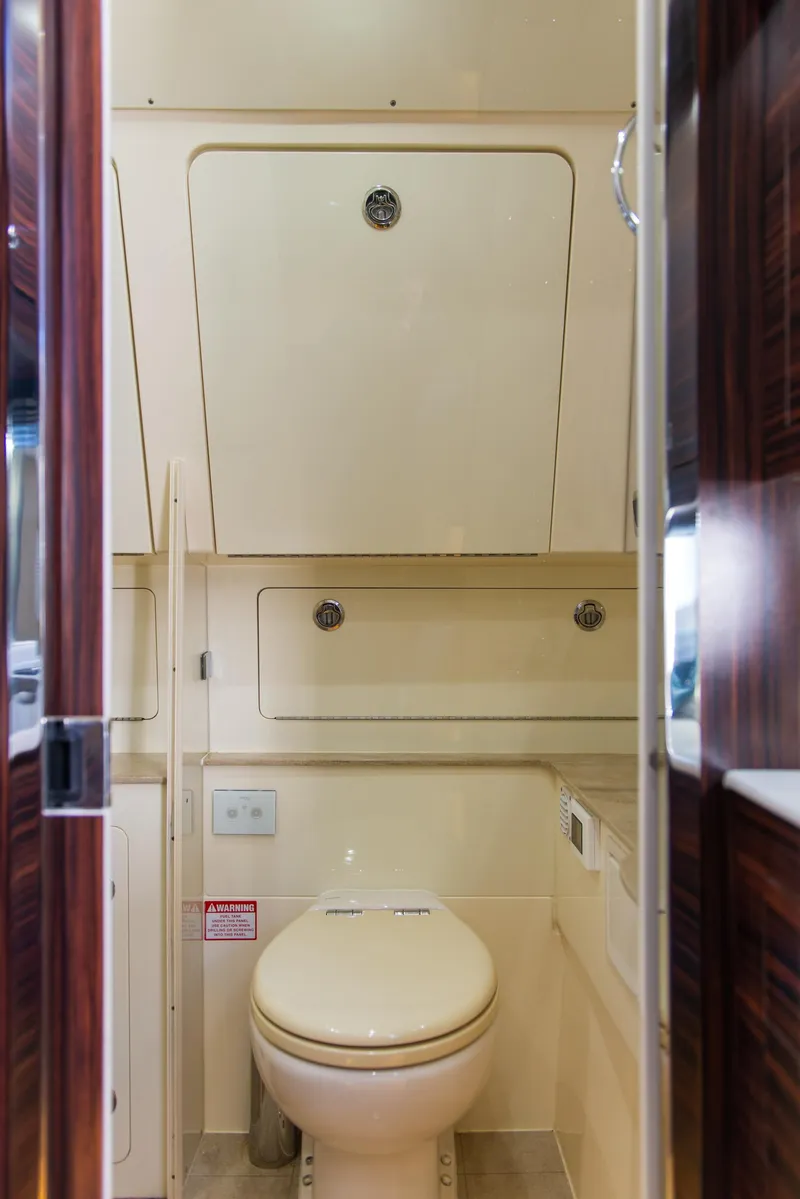 Slide: The Image of 2017 Scout 420 LXF boat bathroom interior with storage cabinets and toilet. - 18