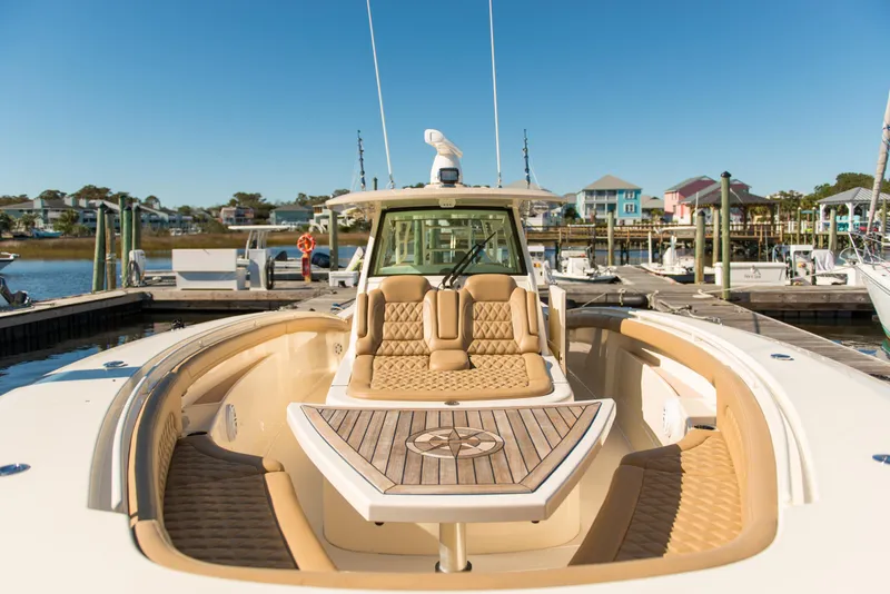 Slide: The Image of 2017 Scout 420 LXF luxury boat docked at marina, showcasing elegant seating and design. - 28