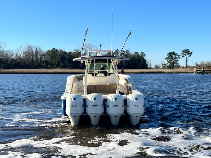 Slide: The Image of 2017 Scout 420 LXF boat with four outboard engines on a calm river. - 3