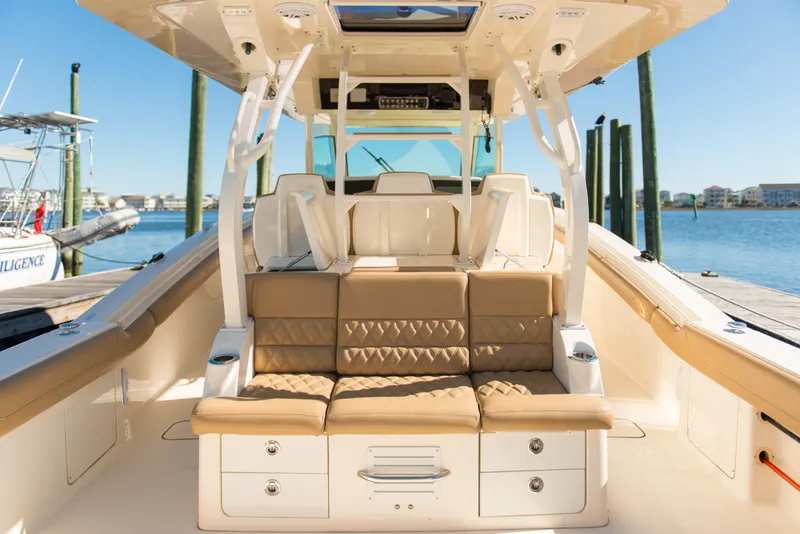 Slide: The Image of Luxurious 2017 Scout 420 LXF boat interior with tan seating and storage, docked by the water. - 39
