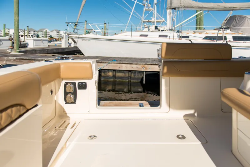 Slide: The Image of 2017 Scout 420 LXF boat interior with tan seating and dock view. - 42