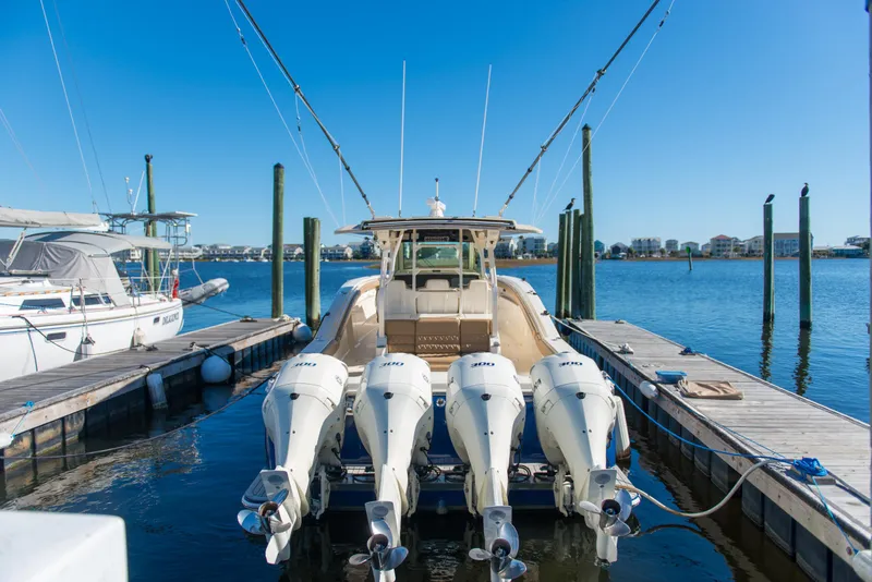 Slide: The Image of 2017 Scout 420 LXF boat docked with four powerful outboard engines. - 45