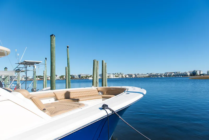 Slide: The Image of 2017 Scout 420 LXF boat docked by calm waters under clear blue sky. - 47
