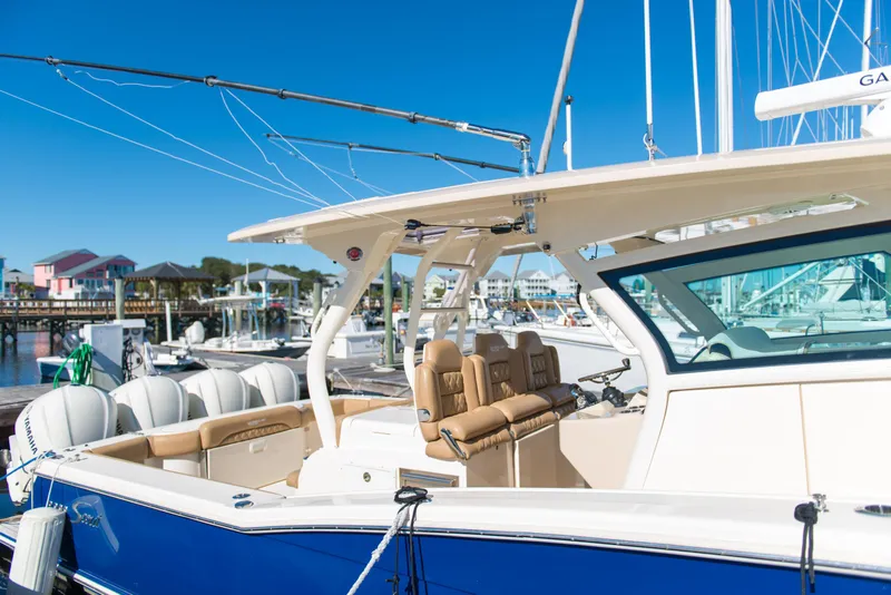 Slide: The Image of 2017 Scout 420 LXF boat docked, featuring luxurious seating and sleek design. - 48