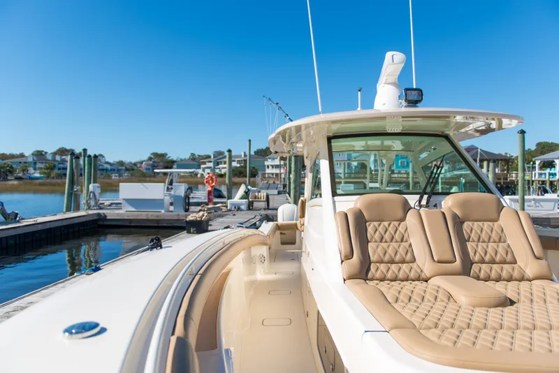 Slide: The Image of 2017 Scout 420 LXF luxury boat docked at marina under clear blue sky. - 49