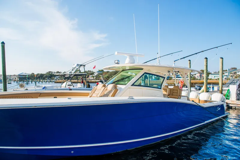 Slide: The Image of 2017 Scout 420 LXF boat docked, featuring sleek blue hull and modern design. - 5