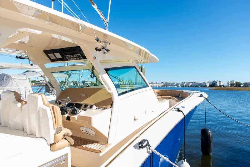 Slide: The Image of 2017 Scout 420 LXF boat docked on a sunny day, showcasing luxury design. - 6