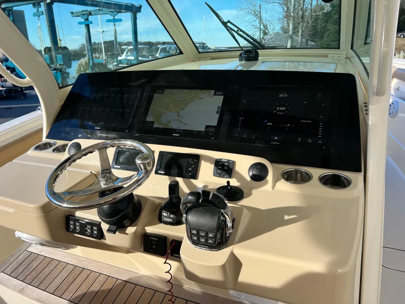 Slide: The Image of 2017 Scout 420 LXF boat dashboard with steering wheel and navigation screens. - 7