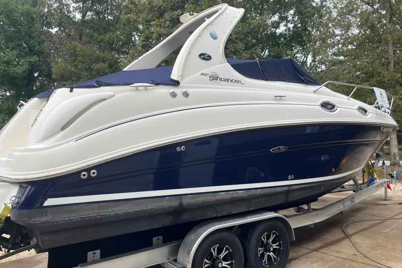 Slide: The Image of 2005 Sea Ray 280 Sundancer boat on trailer, blue and white design, parked outdoors. - 10
