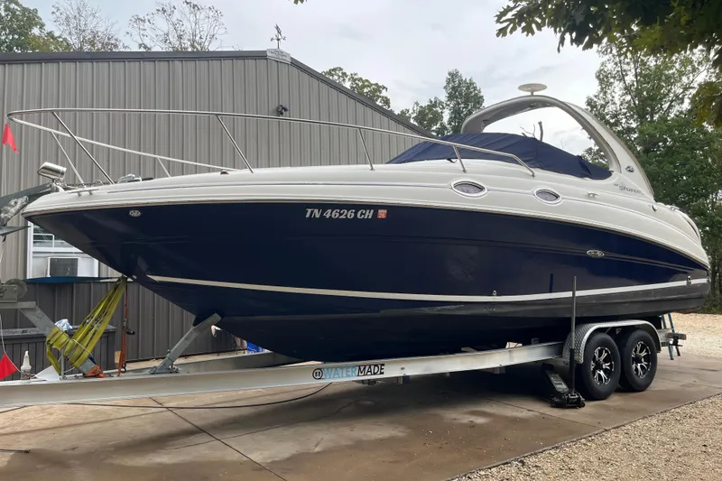 Slide: The Image of 2005 Sea Ray 280 Sundancer boat on trailer, parked outdoors near a building. - 14