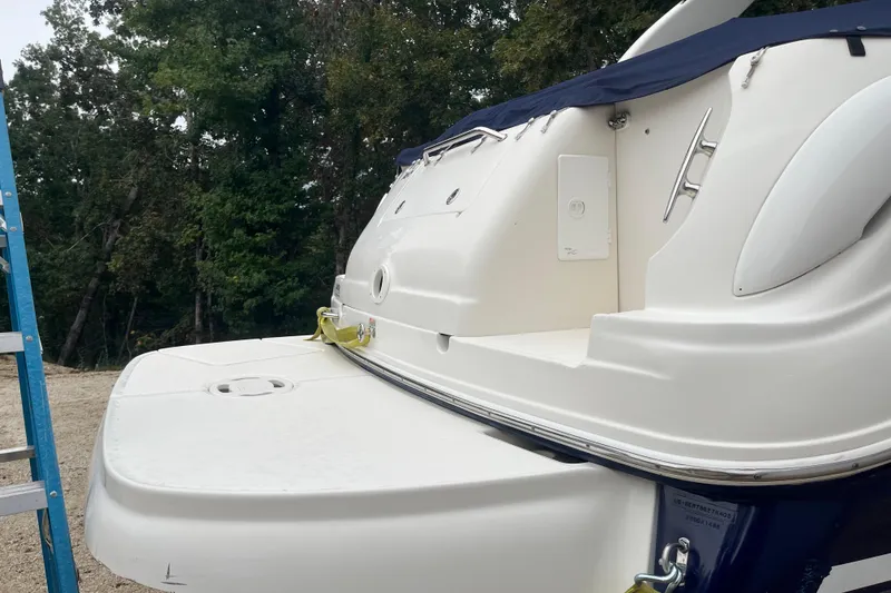 Slide: The Image of 2005 Sea Ray 280 Sundancer boat stern view with swim platform and trees in background. - 16