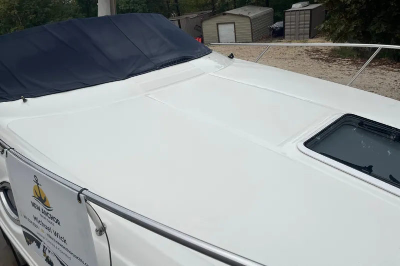 Slide: The Image of 2005 Sea Ray 280 Sundancer boat deck with cover and hatch, parked outdoors. - 19