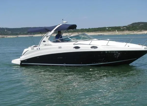 Slide: The Image of 2005 Sea Ray 280 Sundancer cockpit with white seating and control panel. - 2