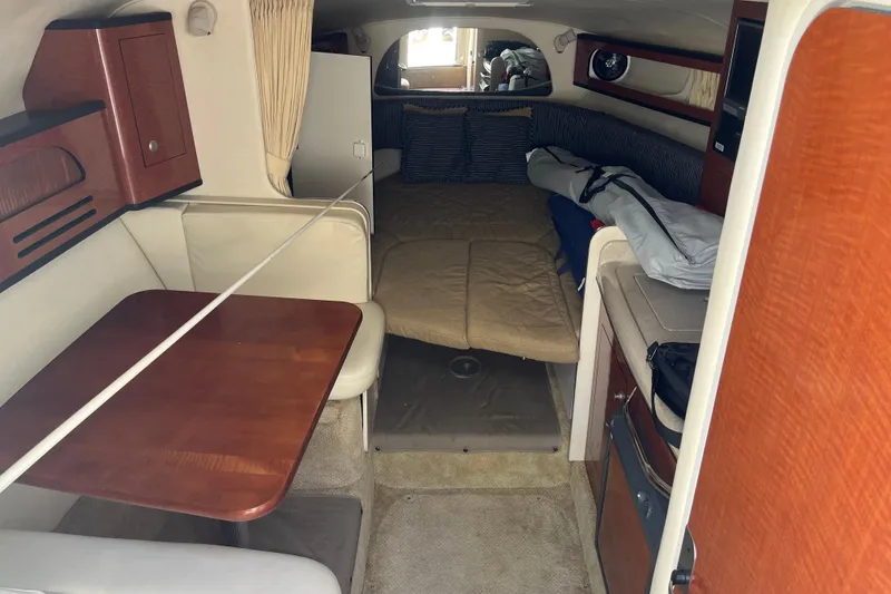 Slide: The Image of Interior of a 2005 Sea Ray Sundancer 280, featuring a cozy cabin with seating and a table. - 30