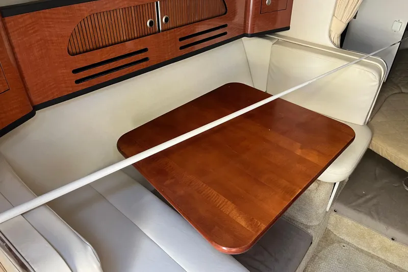 Slide: The Image of Interior of 2005 Sea Ray Sundancer 280 with wooden table and cushioned seating. - 31