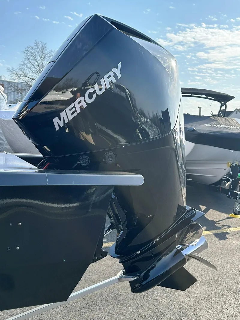 Slide: The Image of 2023 Regency 230 DL3 with Mercury outboard motor under clear sky. - 7