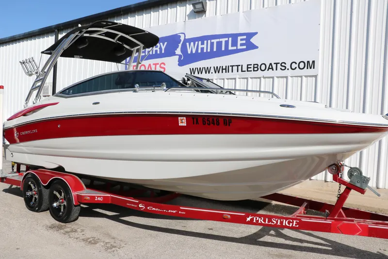 Slide: The Image of 2007 Crownline 240 EX boat on trailer at dealership, featuring red and white design. - 12
