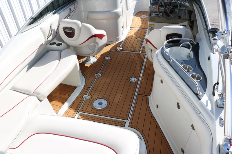 Slide: The Image of 2007 Crownline 240 EX boat interior with white seating and wood flooring. - 19