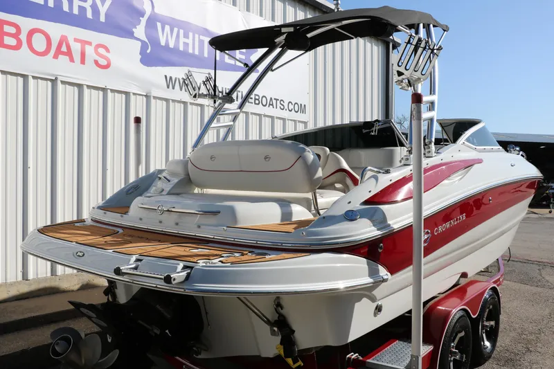 Slide: The Image of 2007 Crownline 240 EX boat with red and white exterior, parked on a trailer. - 4