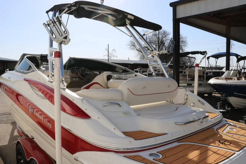Slide: The Image of 2007 Crownline 240 EX boat with red and white design, docked under a canopy. - 8