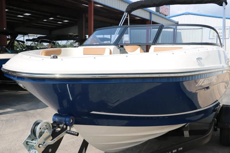 Slide: The Image of 2020 Bayliner VR5 Bowrider I/O boat with blue hull, parked on a trailer. - 10