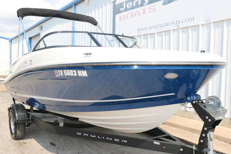Slide: The Image of 2020 Bayliner VR5 Bowrider I/O boat on trailer, blue and white exterior, parked outside. - 12