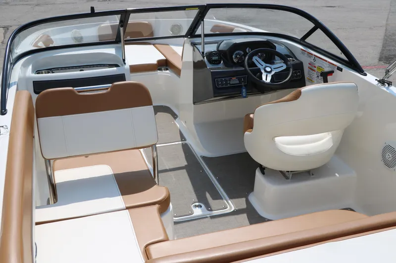 Slide: The Image of 2020 Bayliner VR5 Bowrider I/O interior with tan and white seating, steering wheel, and dashboard. - 17