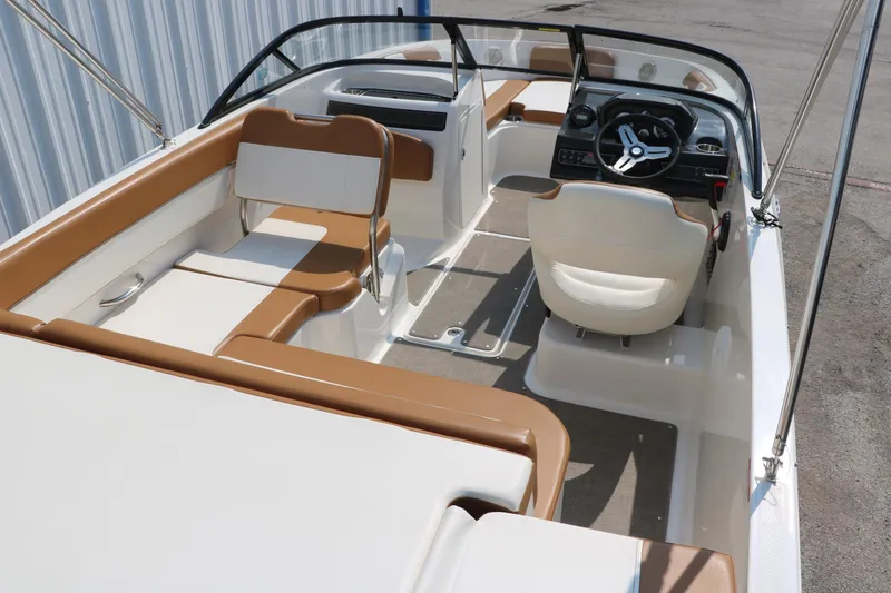 Slide: The Image of 2020 Bayliner VR5 Bowrider I/O interior with tan and white seating, steering wheel, and dashboard. - 19