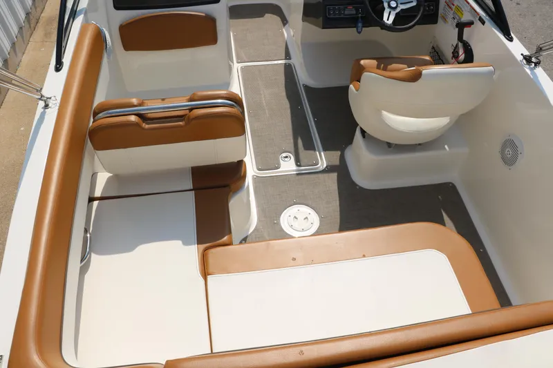 Slide: The Image of 2020 Bayliner VR5 Bowrider I/O interior with tan and white seating, steering wheel, and deck layout. - 36