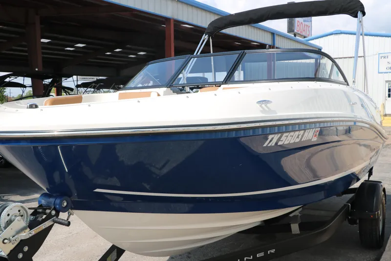 Slide: The Image of 2020 Bayliner VR5 Bowrider I/O boat with blue hull on trailer, parked outdoors. - 9