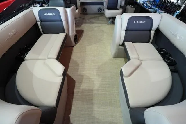 Slide: The Image of 2025 Harris Cruiser 210 interior with beige and gray seating, spacious layout, and cup holders. - 4