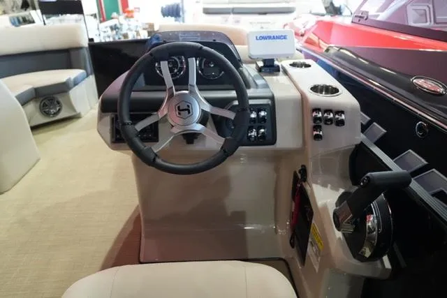 Slide: The Image of 2025 Harris Cruiser 210 boat dashboard with steering wheel and control panel. - 7