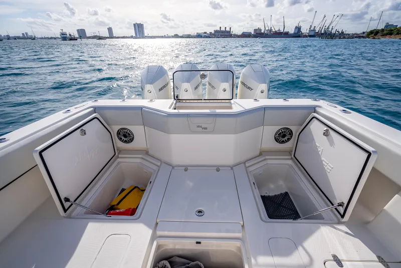 Slide: The Image of 2024 SeaVee 390B boat deck with storage compartments, ocean view, and city skyline. - 11