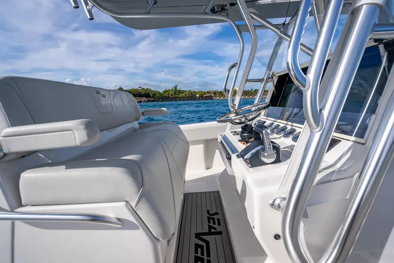 Slide: The Image of 2024 SeaVee 390B boat interior with helm, white seating, and ocean view. - 19