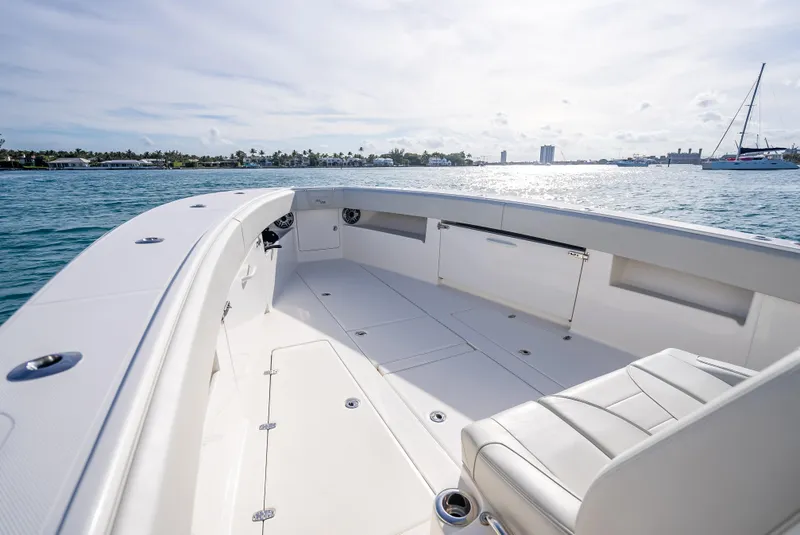 Slide: The Image of 2024 SeaVee 390B boat deck with seating, overlooking calm waters and distant shoreline. - 24