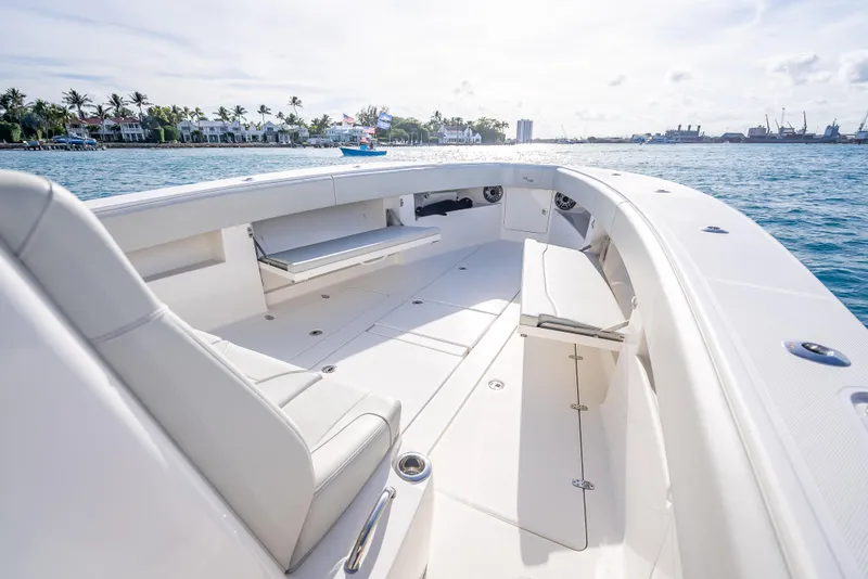 Slide: The Image of 2024 SeaVee 390B boat interior with spacious seating, docked by the ocean. - 26