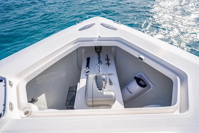 Slide: The Image of 2024 SeaVee 390B boat anchor compartment with chain and storage, on clear blue water. - 31
