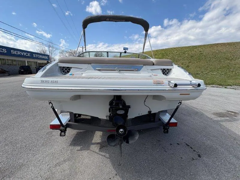 Slide: The Image of 2019 Crownline 215 SS boat, rear view, parked on a trailer under a blue sky. - 14